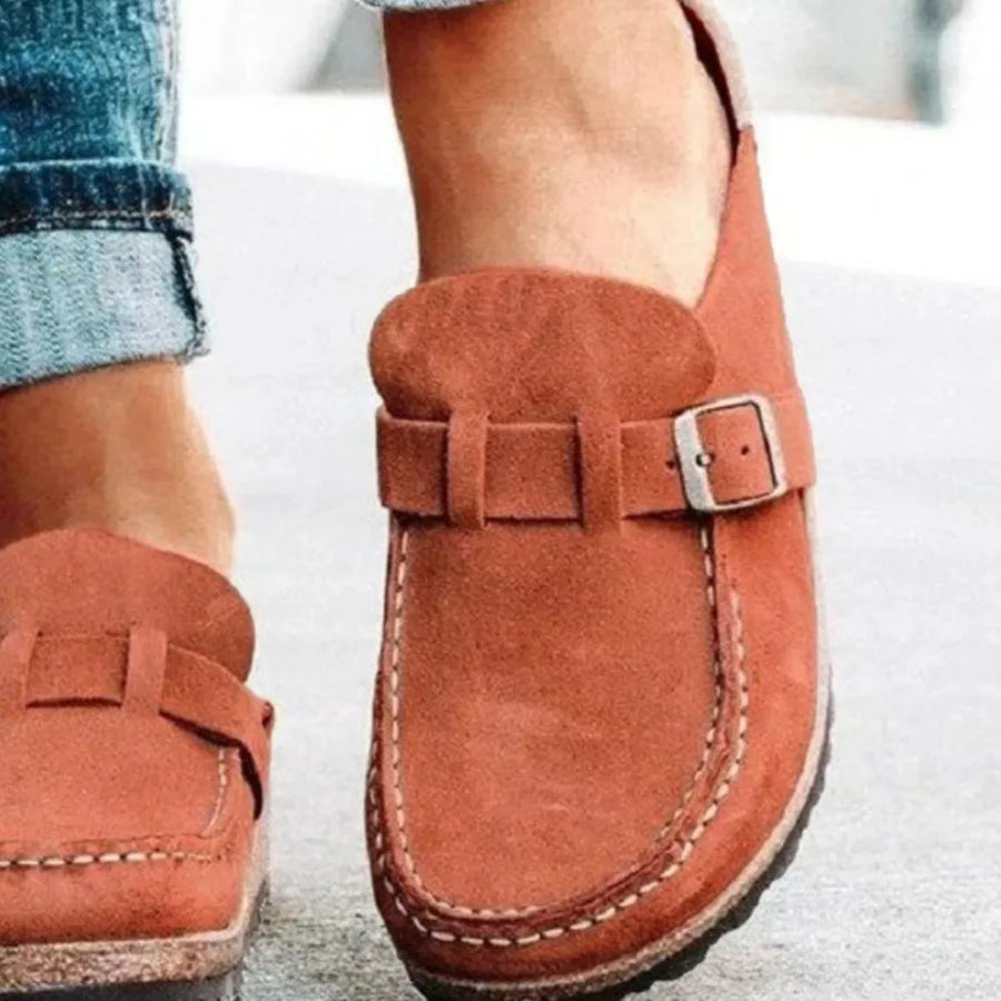 Suede buckle mule loafers in caramel with white stitching detail.