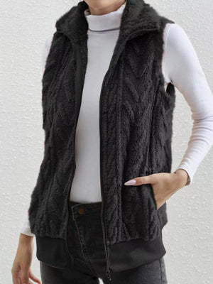 Black faux fur zip-up vest with chevron pattern and pockets.