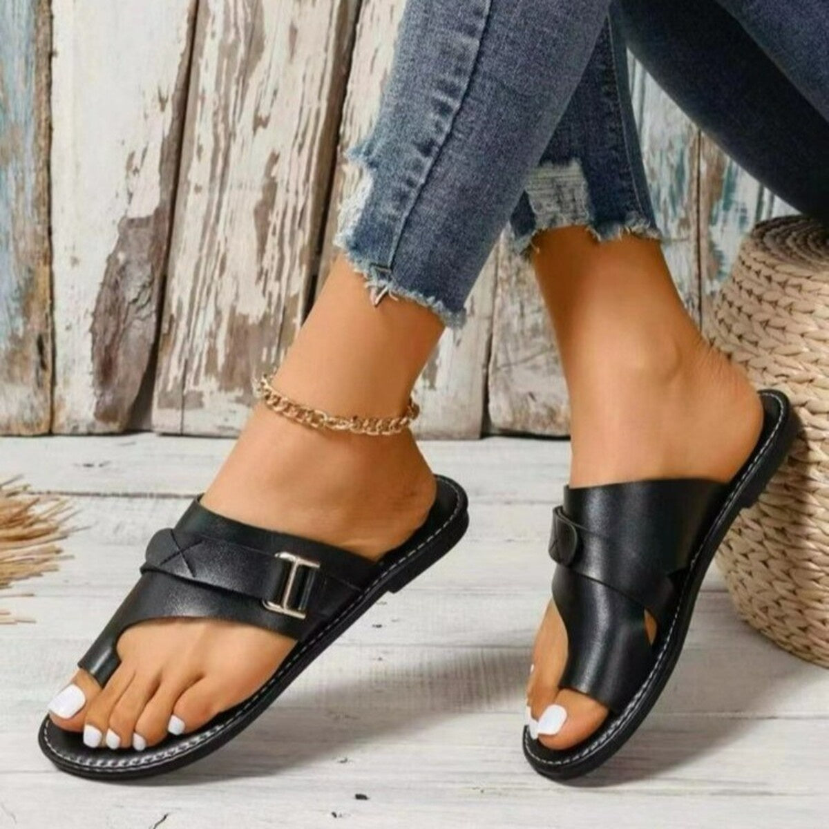 Black toe ring sandals with buckle detail and crisscross straps.