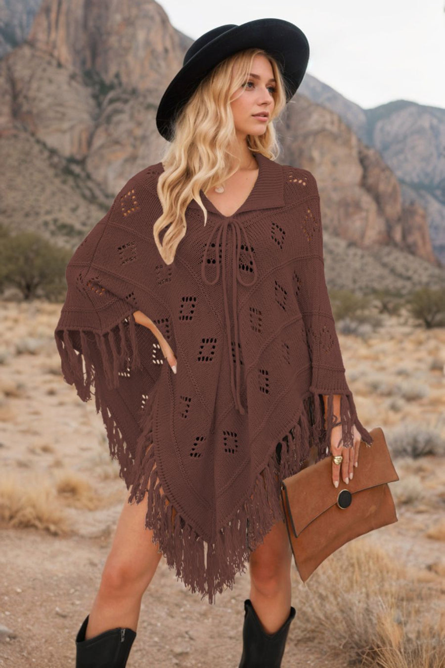 Brown knit poncho with geometric cutouts and fringe, featuring a tie-neck and collar.