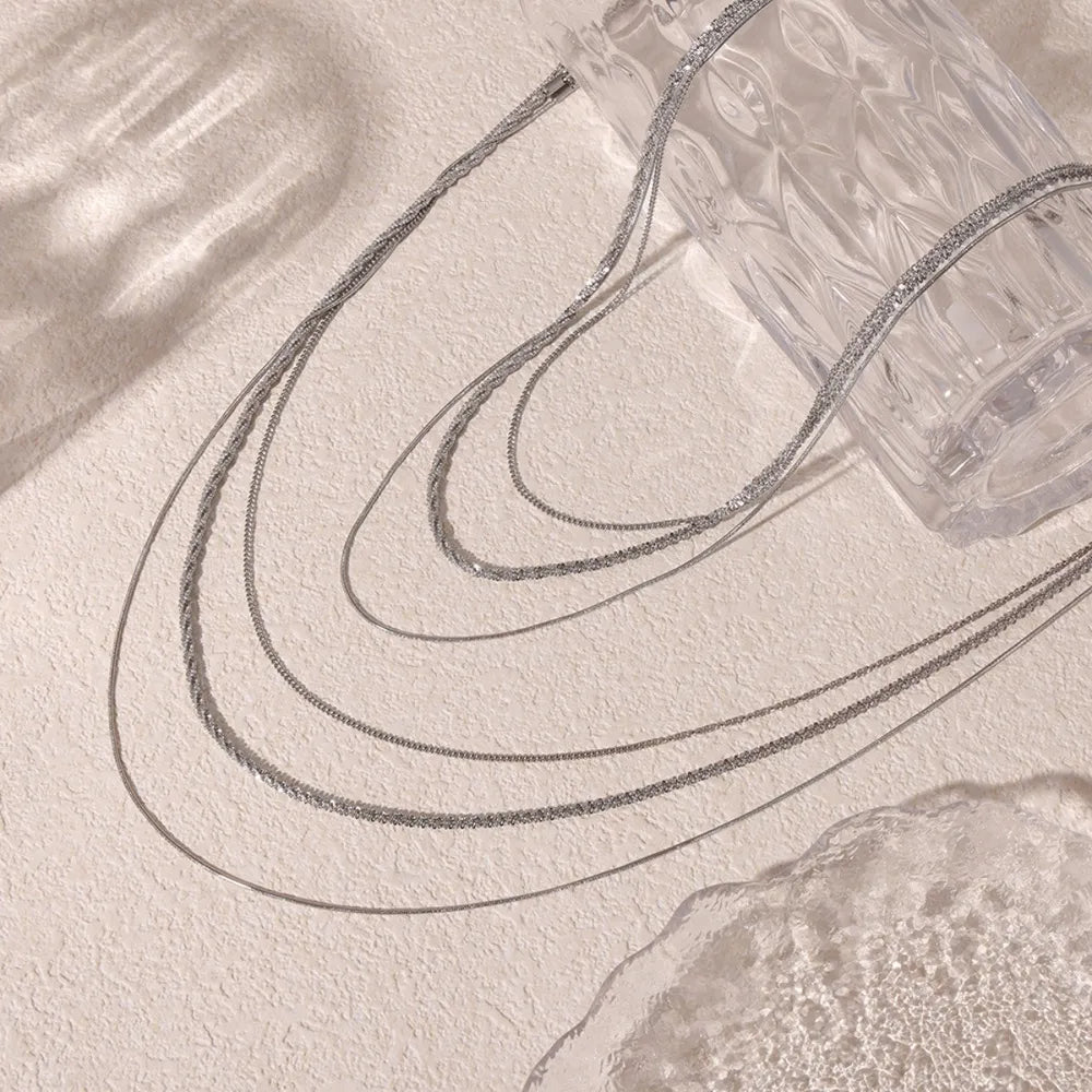 Delicate three-strand silver crystal necklace with layered chains.