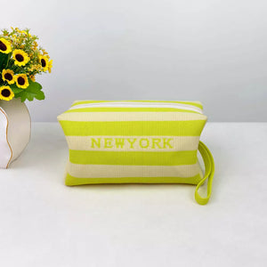Striped cosmetic bag in yellow with New York text and a wrist strap
