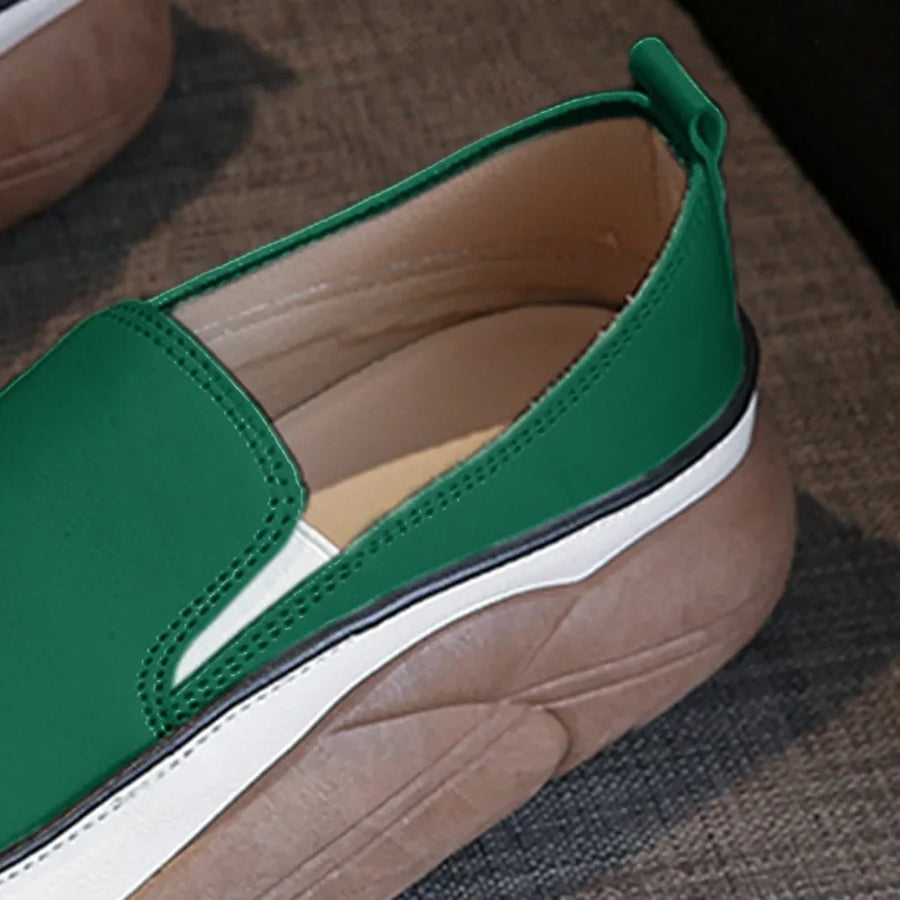 Turquoise slip-on sneakers with a sculpted platform sole and white trim.