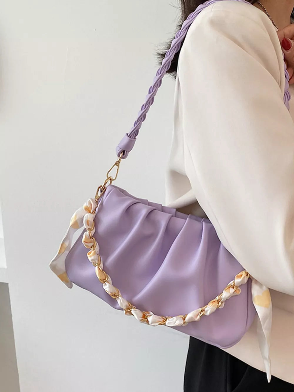 Purple ruched mini shoulder bag with braided strap and chain detail.