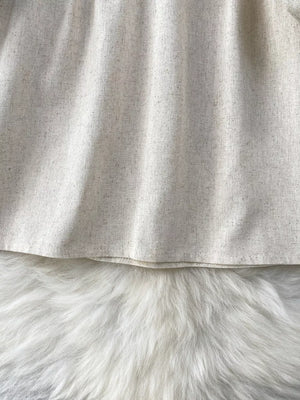 Cream tie-neck blouse with textured fabric and delicate embroidery detail