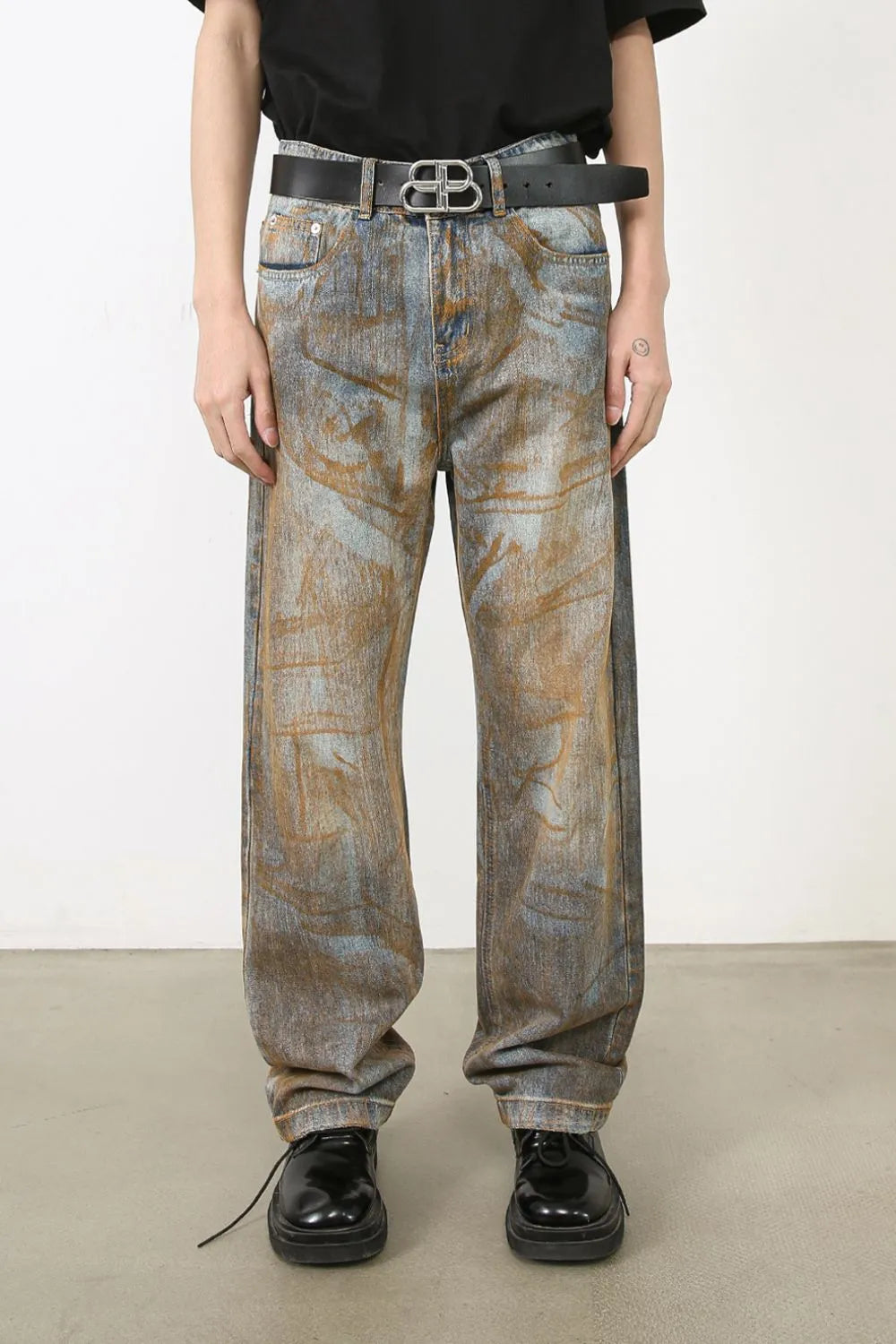 Acid wash denim relaxed fit trousers in medium blue with brown abstract pattern.