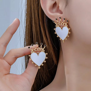 White heart crown stud earrings with gold trim and black accents.