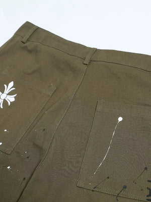 Olive green cotton cargo pants with white paint splatter design and graphic detail.