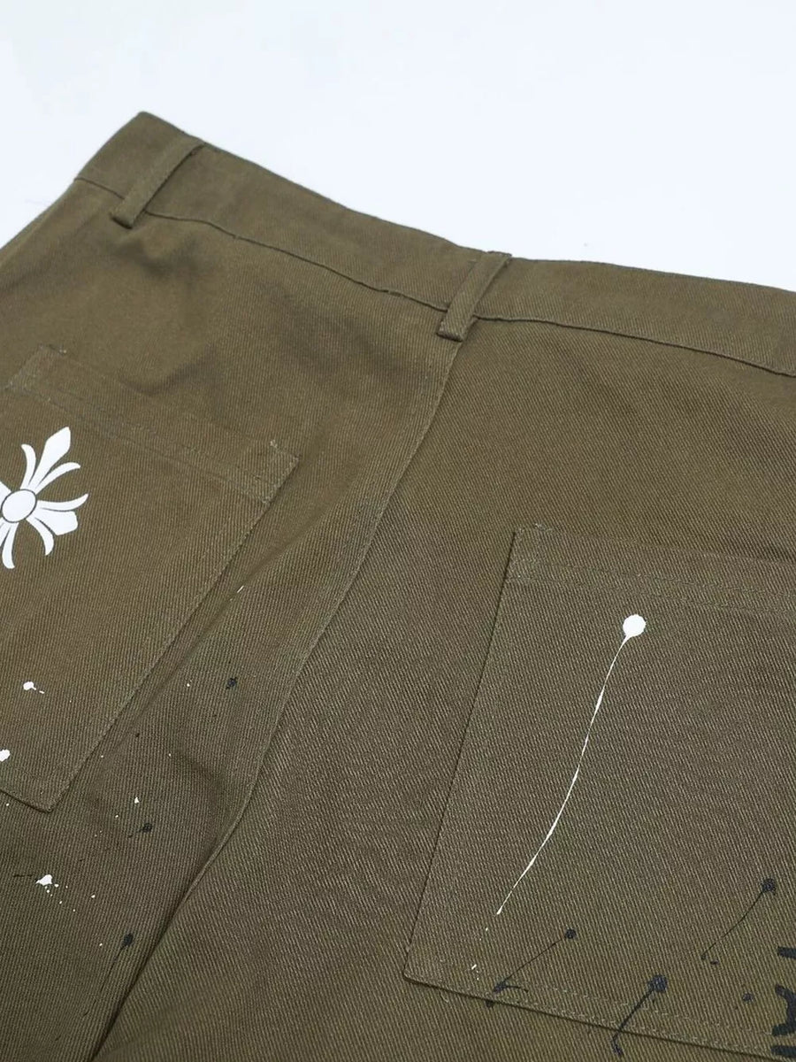 Olive green cotton cargo pants with white paint splatter design and graphic detail.
