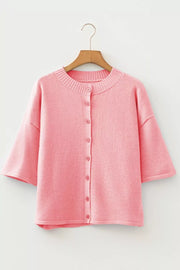 Pink boxy knit cardigan with button front and short sleeves.