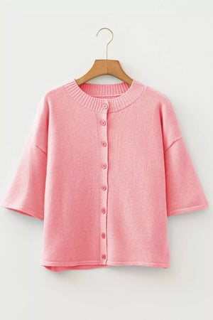 Pink boxy knit cardigan with button front and short sleeves.