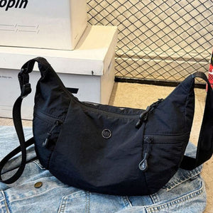 Black nylon crossbody bag with adjustable strap and zippered pockets