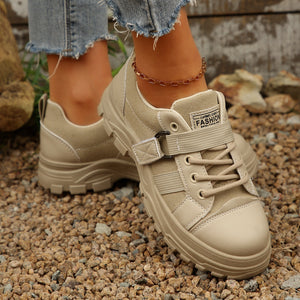 Beige lace up platform casual sneakers with chunky sole and adjustable strap detail.