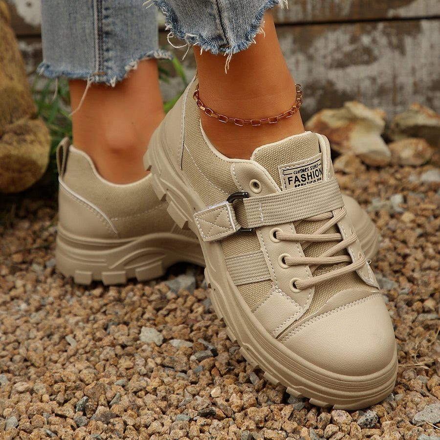 Beige lace up platform casual sneakers with chunky sole and adjustable strap detail.