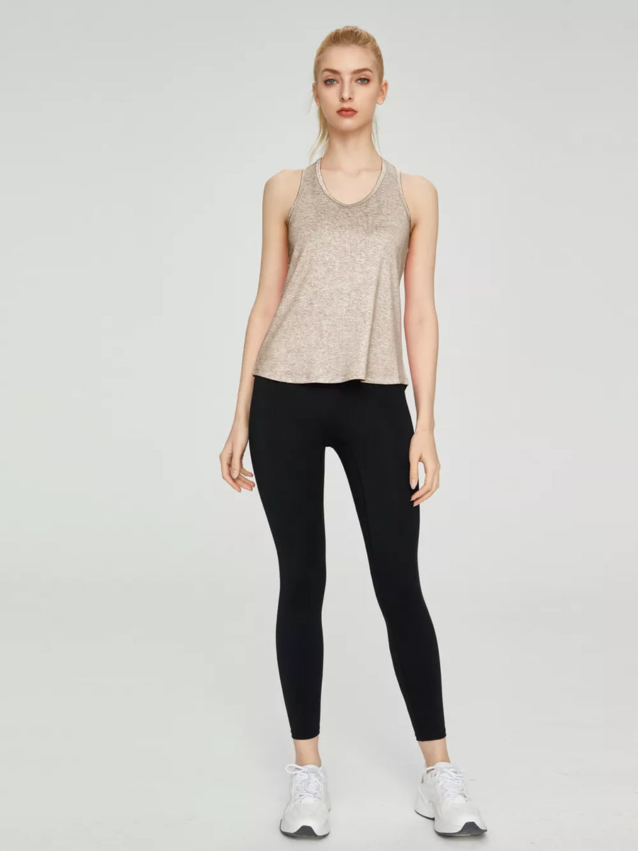 Lightweight heathered tank top in beige with a V-neck and racerback, paired with black leggings.
