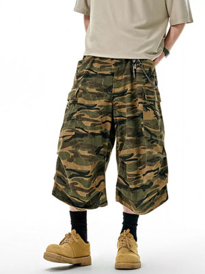 Oversized cotton camo cargo shorts in olive brown with multiple pockets and a chain detail.