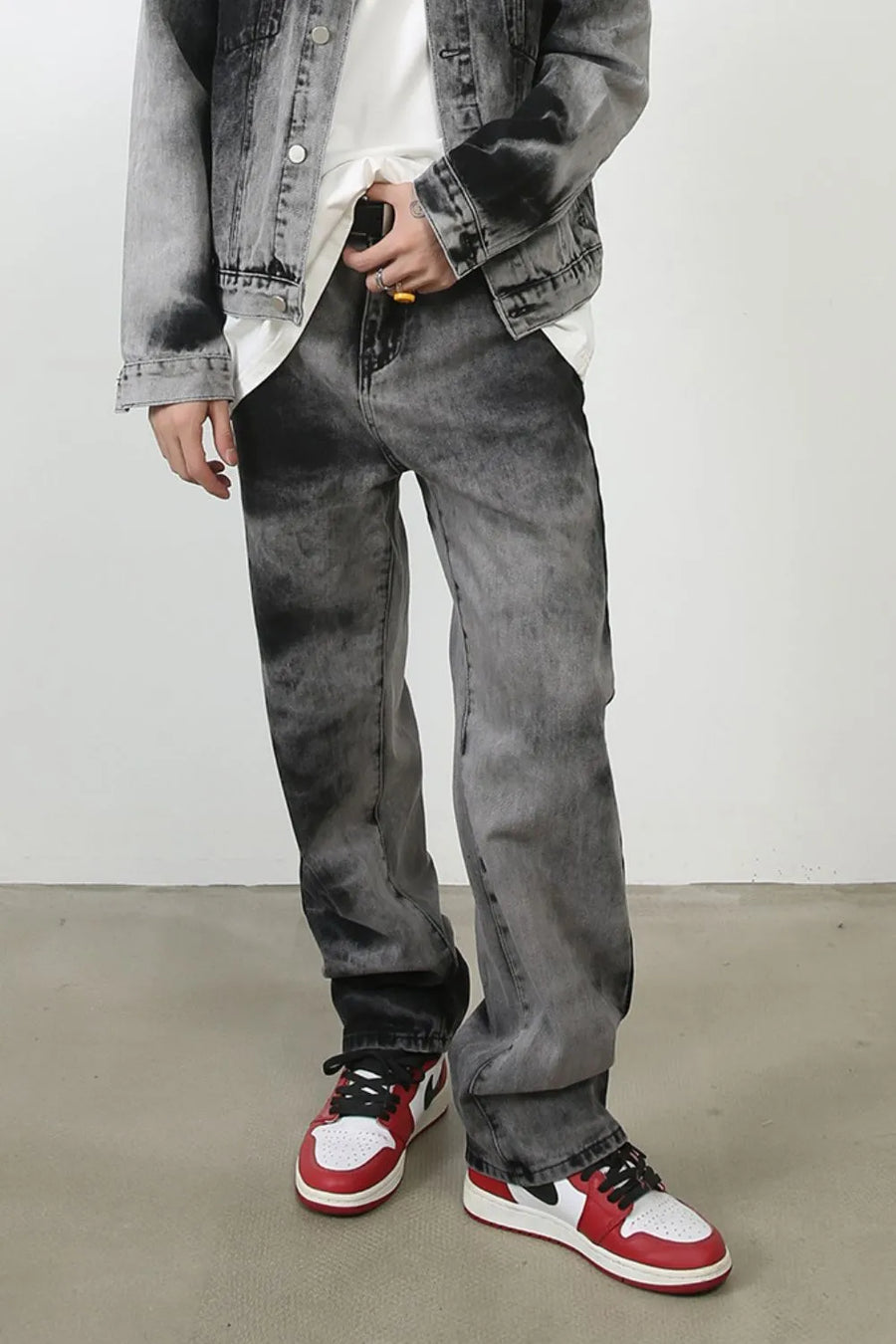 Charcoal wash straight leg denim jeans with a faded, marbled pattern.