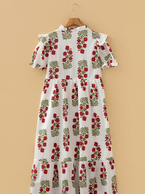 White cotton mini dress with red floral print, ruffled neckline and sleeves.
