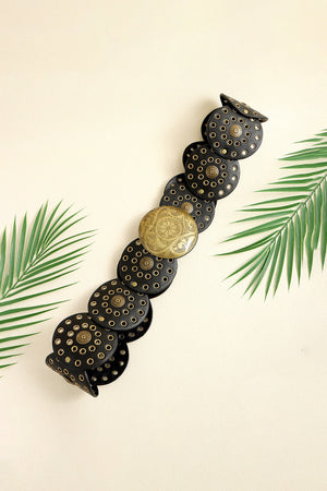 Black leather belt with round silver-tone disc embellishments and a large ornate gold-tone buckle.