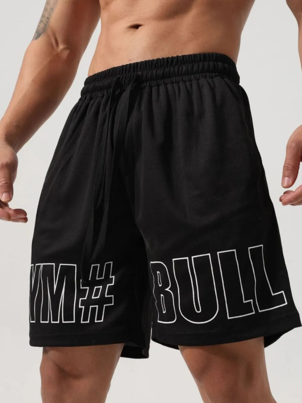 Black mesh gym shorts with white graphic text detail on the leg.