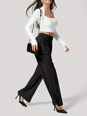 Black pleated wide-leg tailored trousers with a high waist and relaxed fit.
