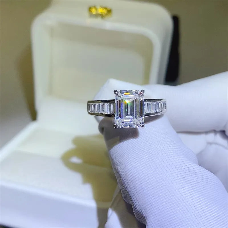 Emerald cut moissanite ring with baguette accents in silver sterling.