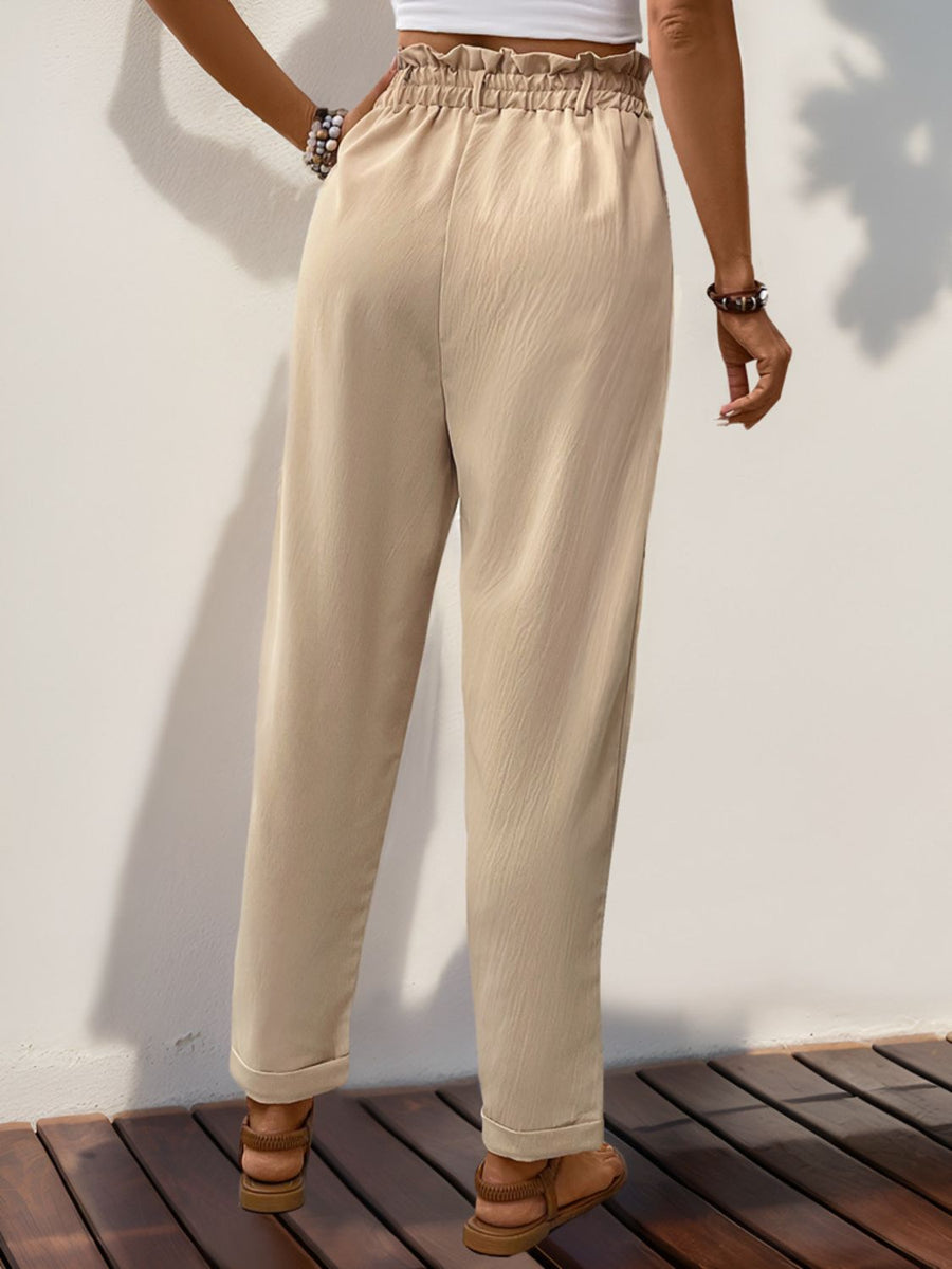 Tan linen blend trousers with gathered waistline and cuffed hems.