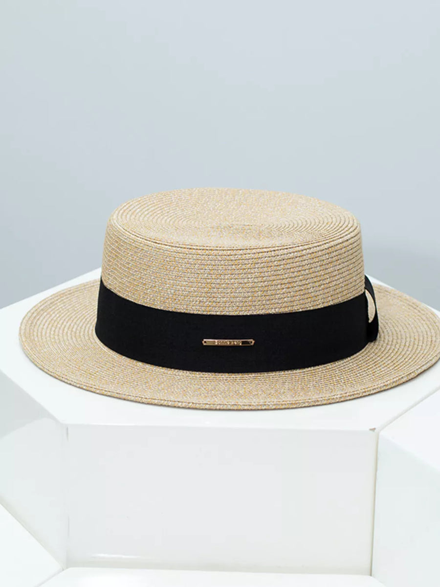 Elegant straw boater hat in beige with a black ribbon band and gold accent