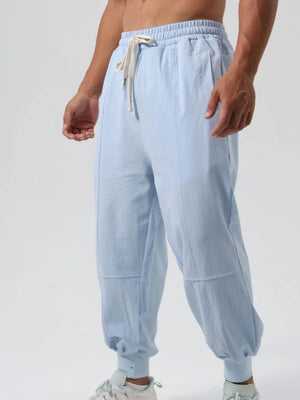 Light blue relaxed fit joggers with seam details and adjustable drawstring waist.