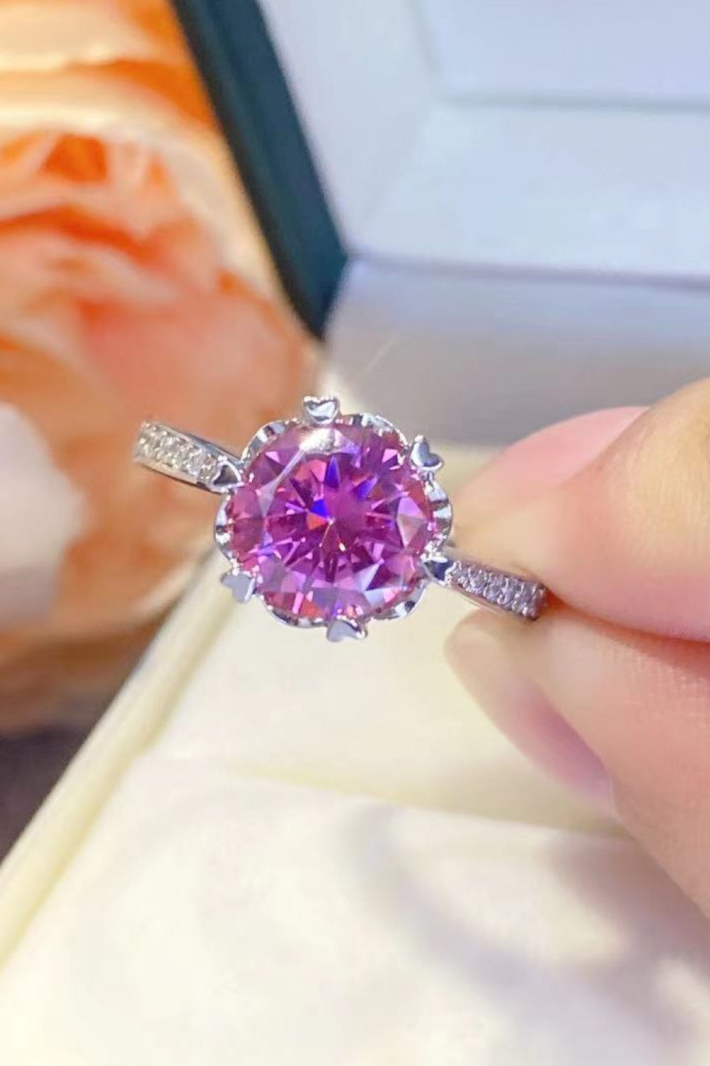 Floral-inspired pink moissanite and sterling silver ring with diamond accents.