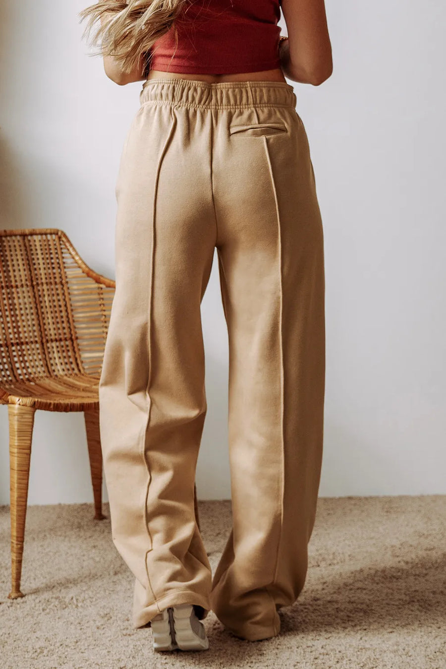 Tan wide-leg sweatpants with relaxed seam detail and elastic waistband.