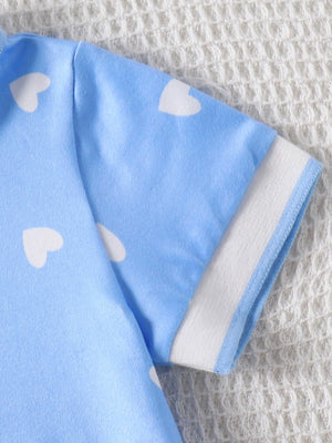 Baby dress in light blue with white heart print and contrasting white sleeve trim.