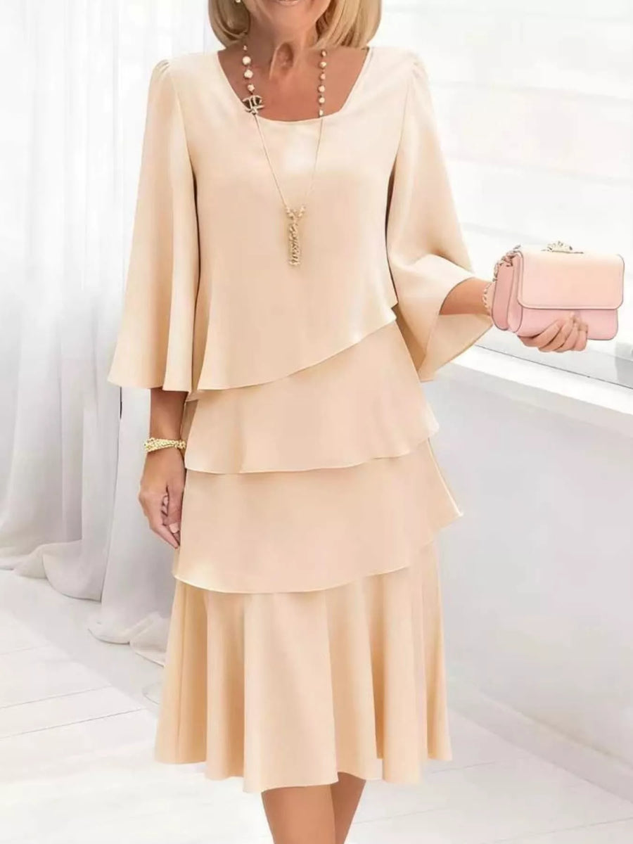 Elegant tiered dress in tan with 3/4 bell sleeves and a square neckline.