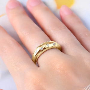 Gold dome ring with scattered starburst details and small stones.