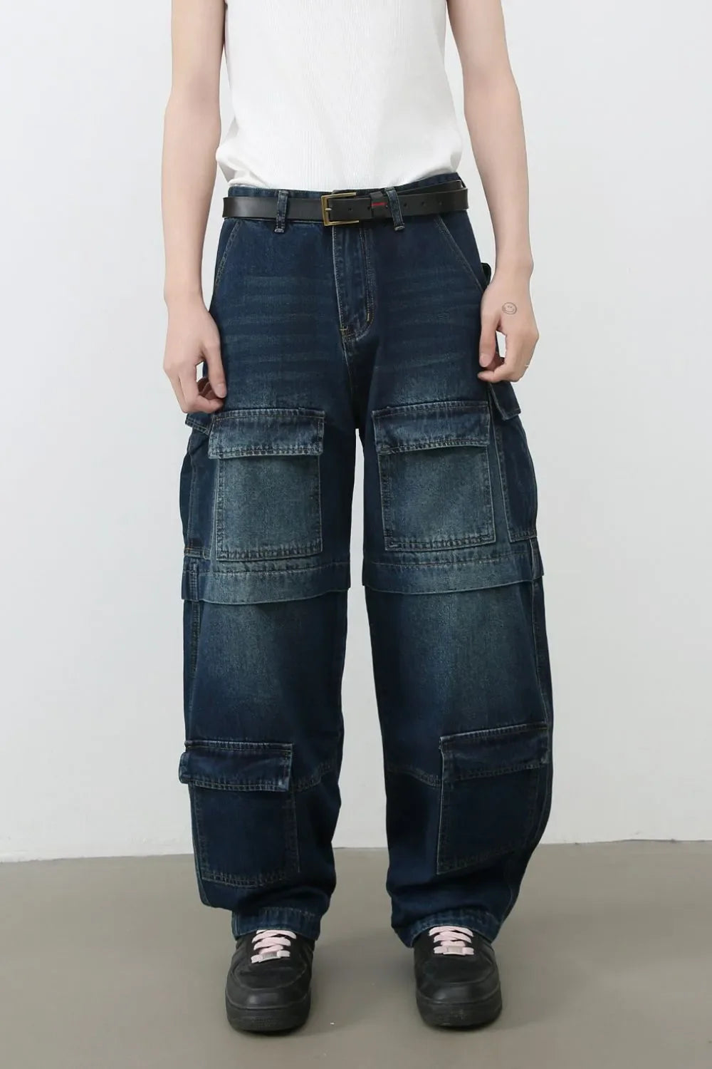 Dark denim cargo pants with layered pockets and a relaxed fit.