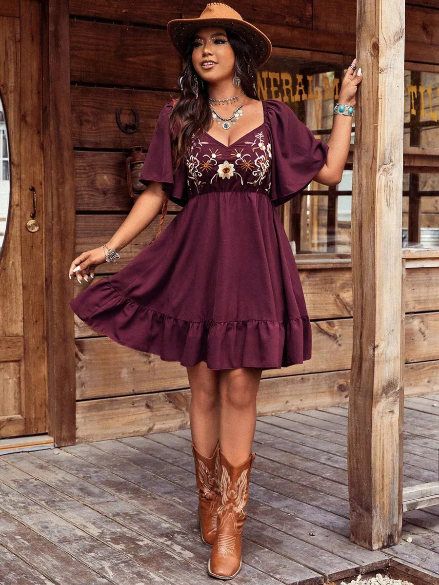 Wine red flutter sleeve dress with floral embroidery and ruffled hem.