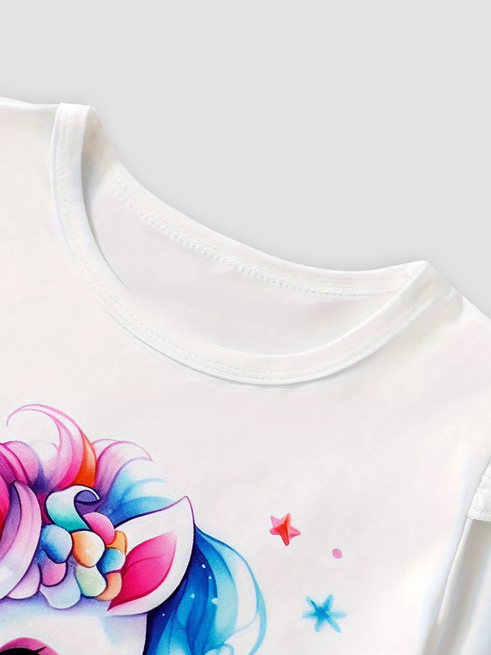 White baby cotton set with unicorn graphic and ruffle sleeves.
