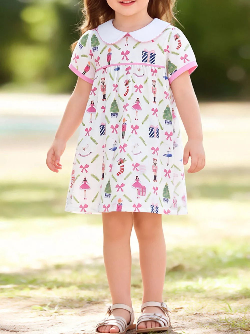 Toddler a-line dress with Peter Pan collar, short sleeves, and a whimsical nutcracker print.