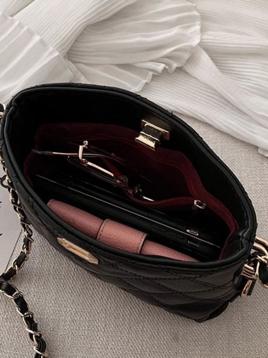 Black quilted pu leather crossbody bag with gold chain strap, showing interior contents.