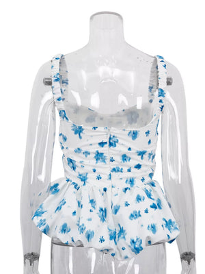 White peplum top with blue floral print, square neckline, and ruffled straps.