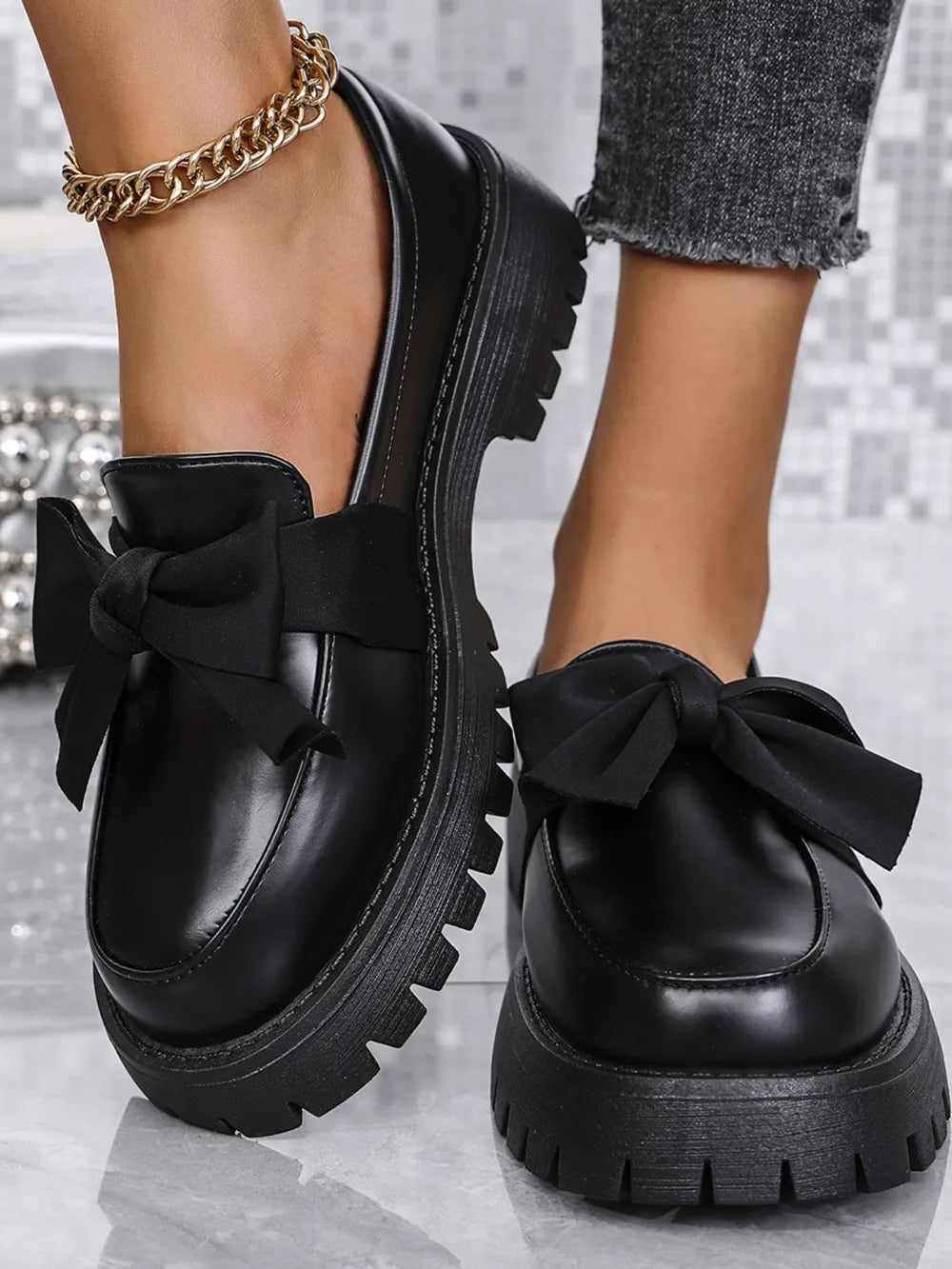 Black matte platform bow loafers with chunky lug sole.