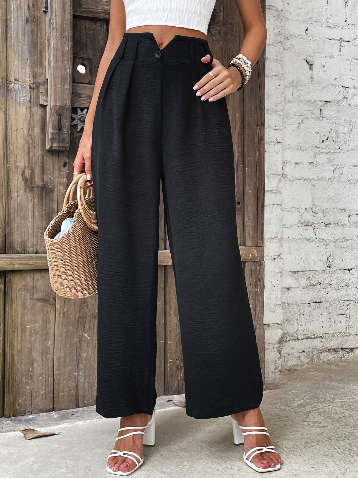 Black textured wide-leg tailored trousers with a high waist and button detail.
