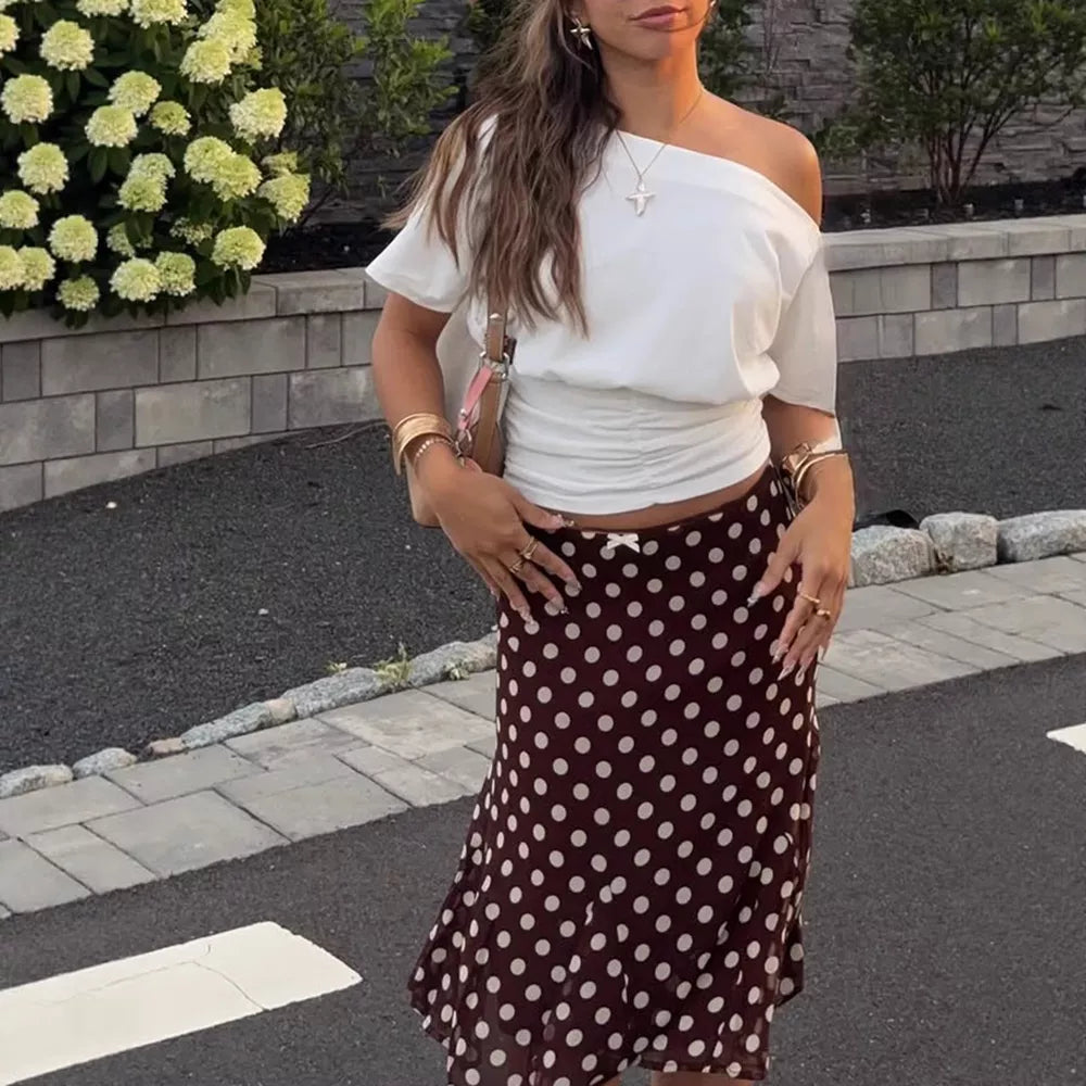 Charming A-line skirt in dark brown with white polka dots and a bow detail.