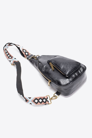 Black textured sling bag with woven strap detail and adjustable strap.