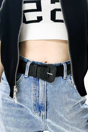 Black glitter belt with square buckle detail worn with light wash jeans.