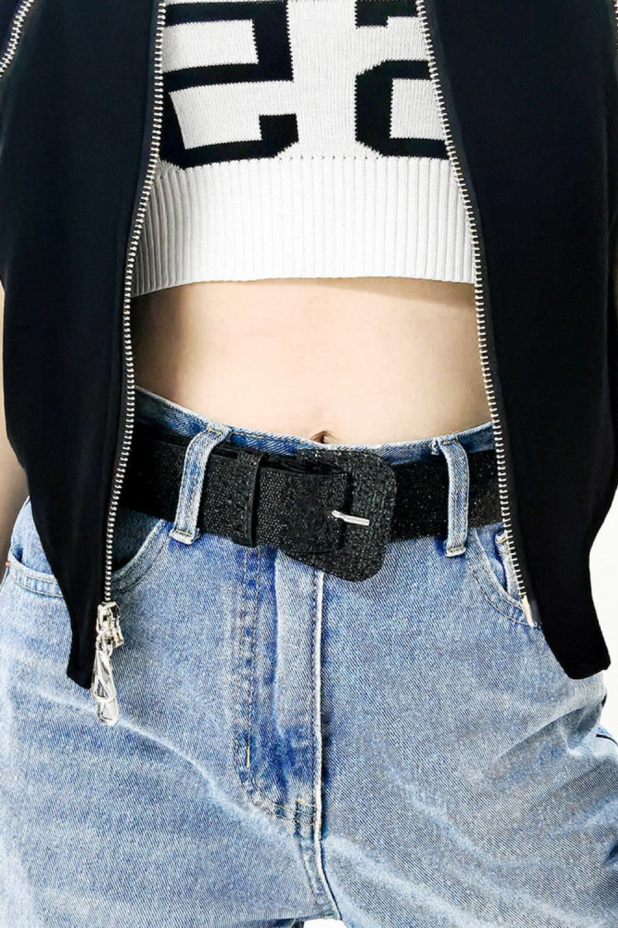 Black glitter belt with square buckle detail worn with light wash jeans.