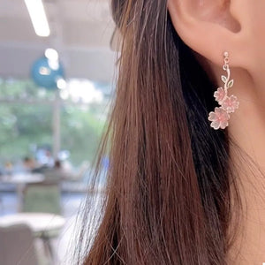 Asymmetrical blush pink floral drop earrings with delicate leaves.