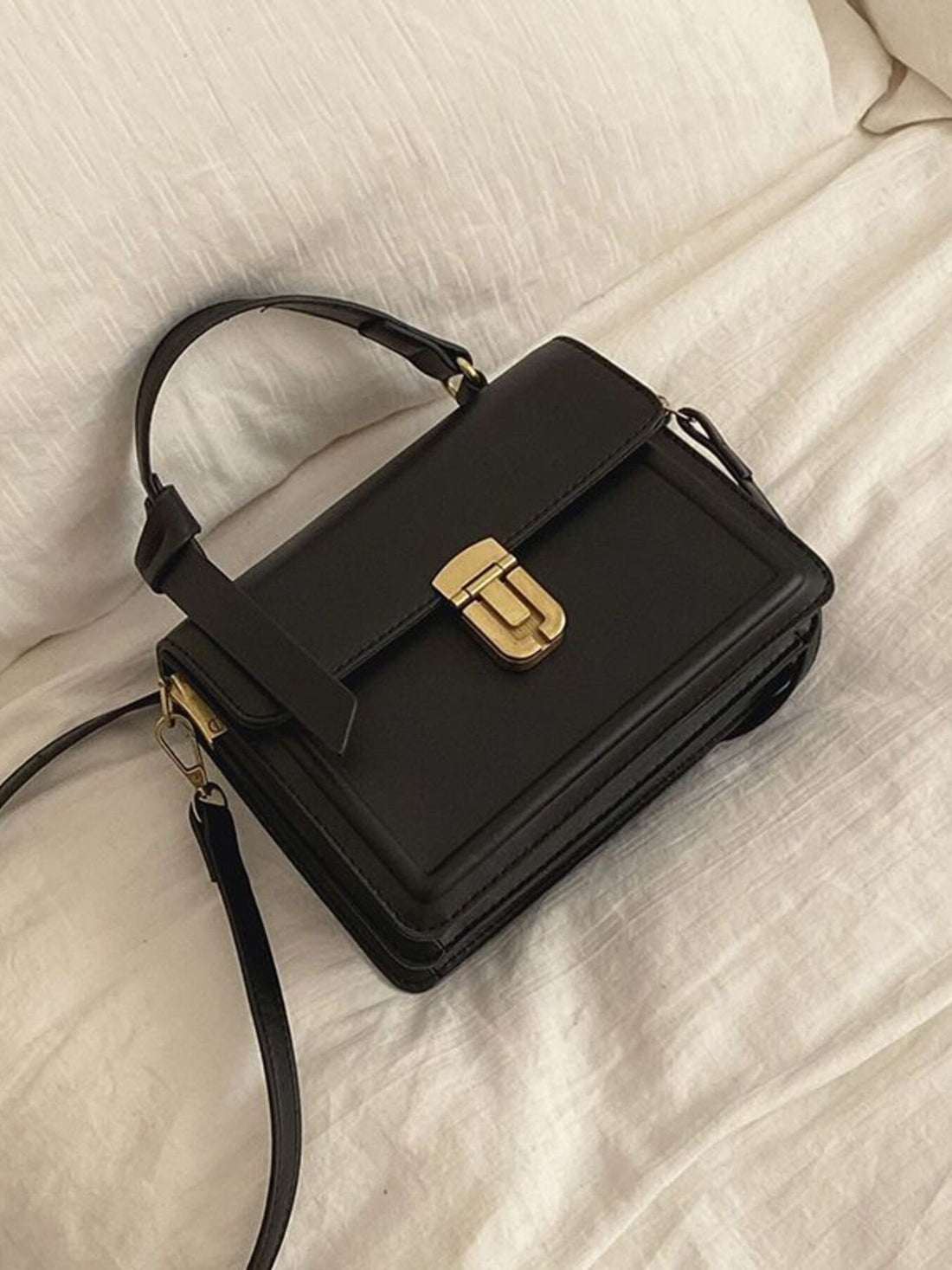 Small black pu leather crossbody bag with gold clasp and top handle