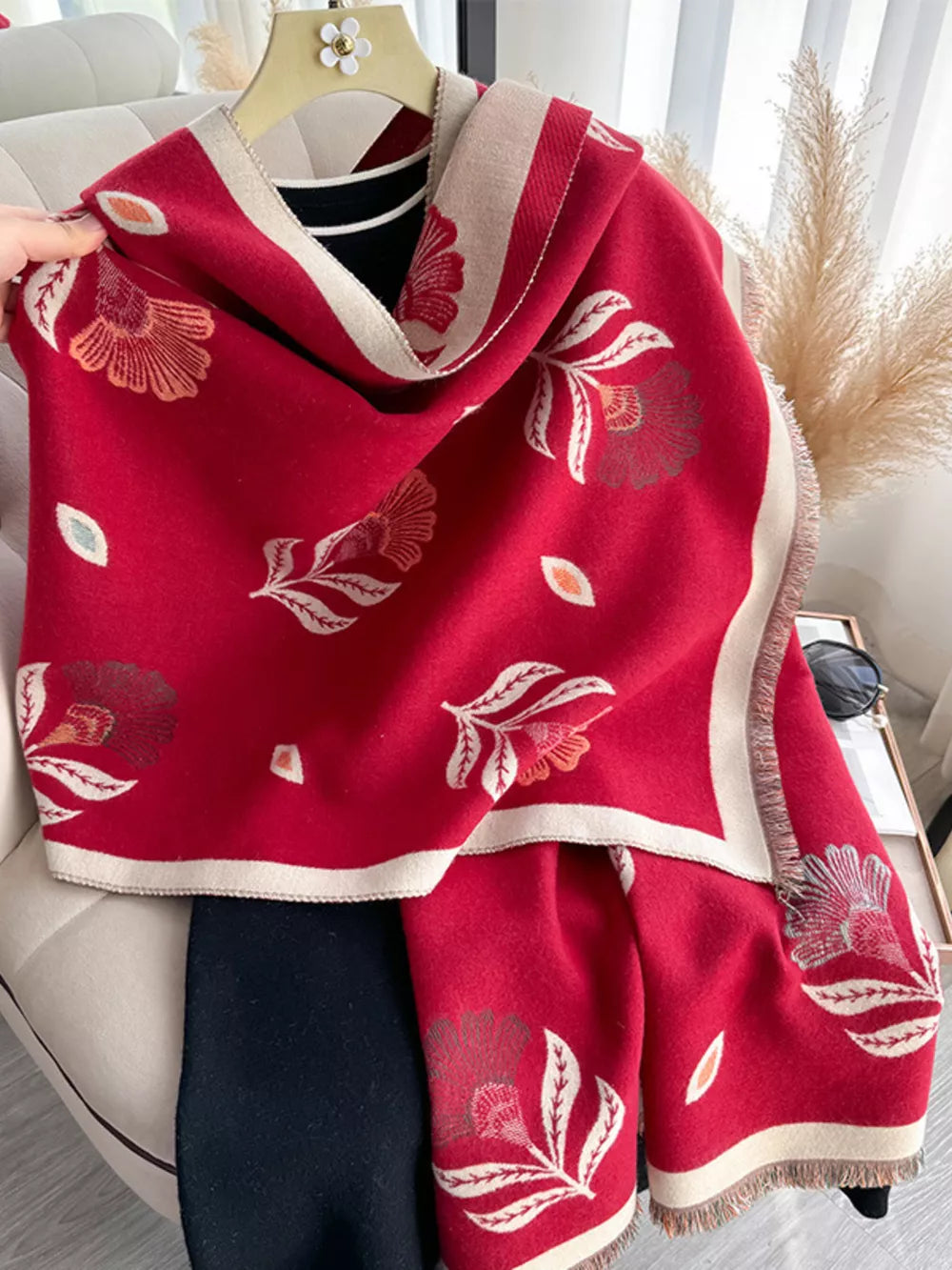 Red floral print fringed shawl with cream border and frayed edges.