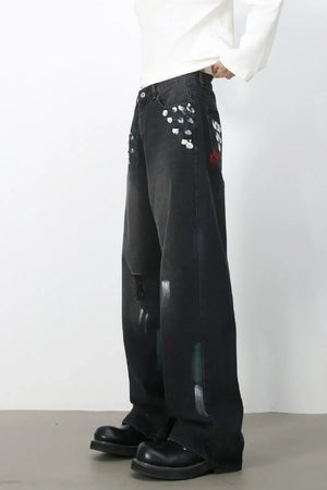 Dark wide-leg jeans with painterly brushstroke details and distressed accents.